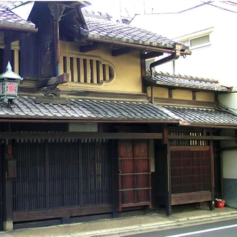 Traditional machiya townhouses on a quiet Kyoto street with wooden facades and noren curtains.