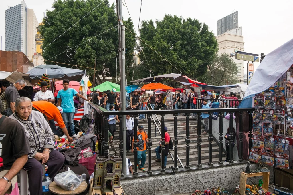 Colorful market stalls in Mexico City with produce, food vendors, and local shoppers.