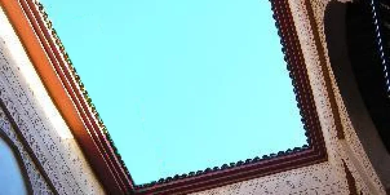 Open-air courtyard of a traditional riad in Marrakech with tiles, plants, and Moroccan architecture.