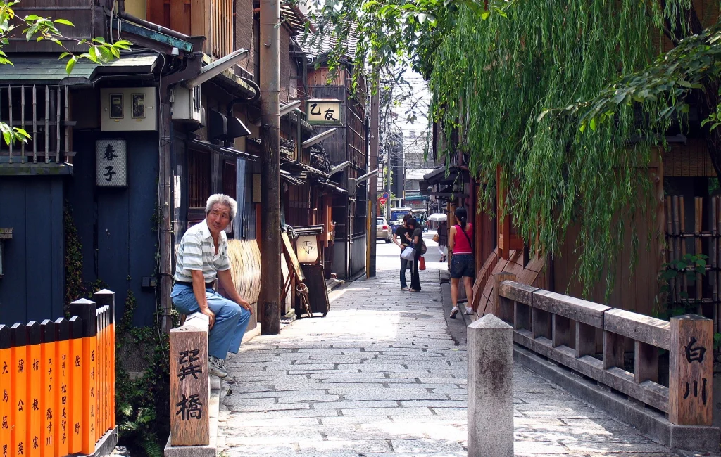 Traditional street in Gion Kyoto with wooden buildings and lanterns.